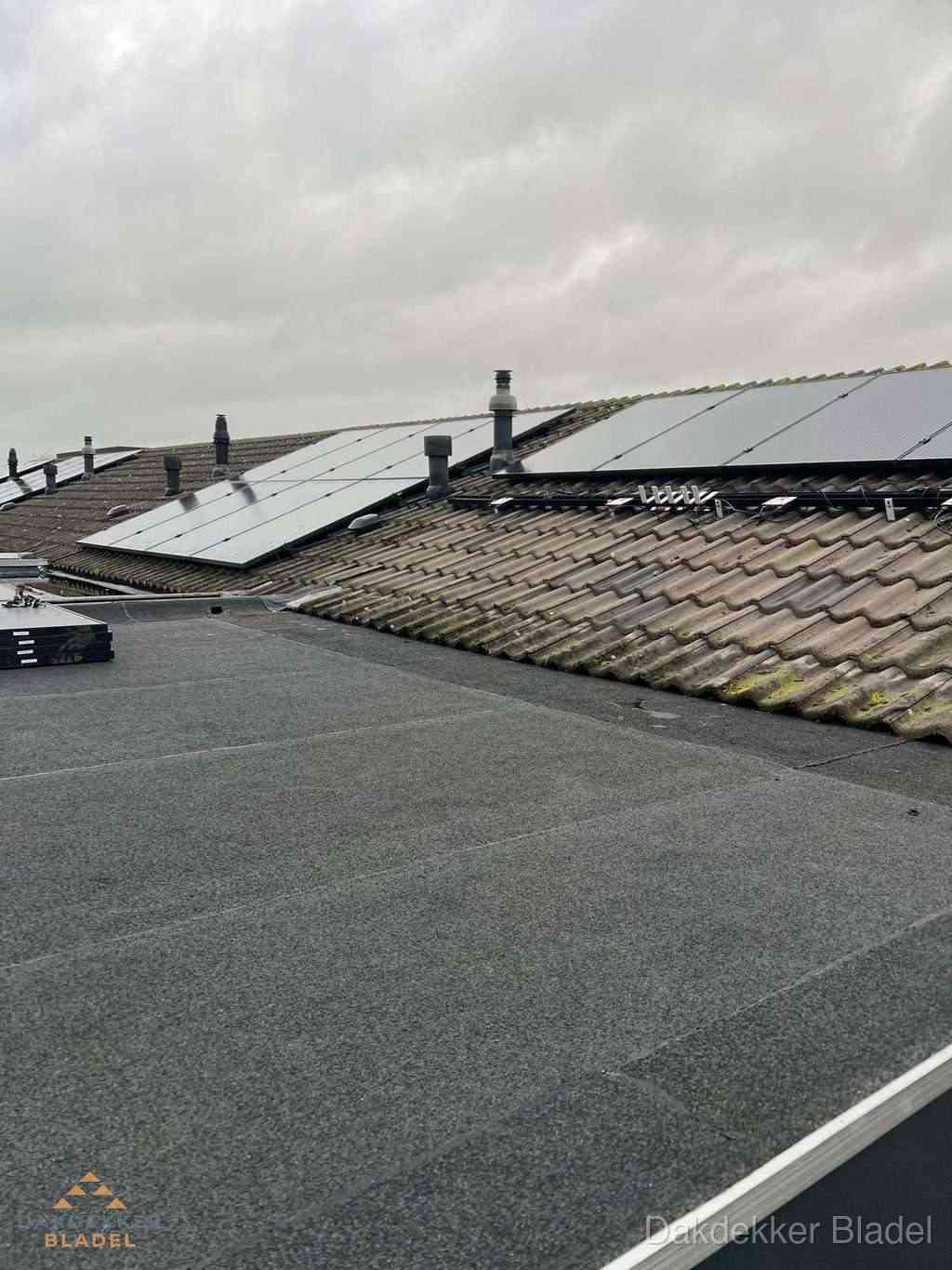 Plat dak inspectie met bitumen bedekking naast schuin pannendak in Bladel