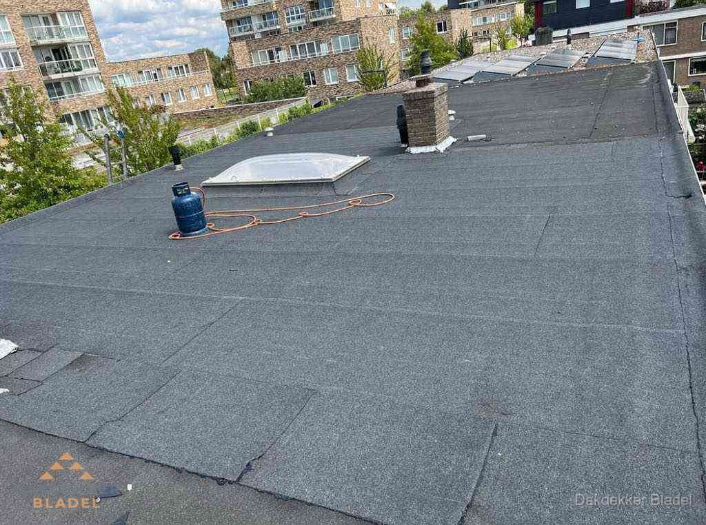 Bitumen dakbedekking op plat dak met lichtkoepel en schoorsteen in Bladel