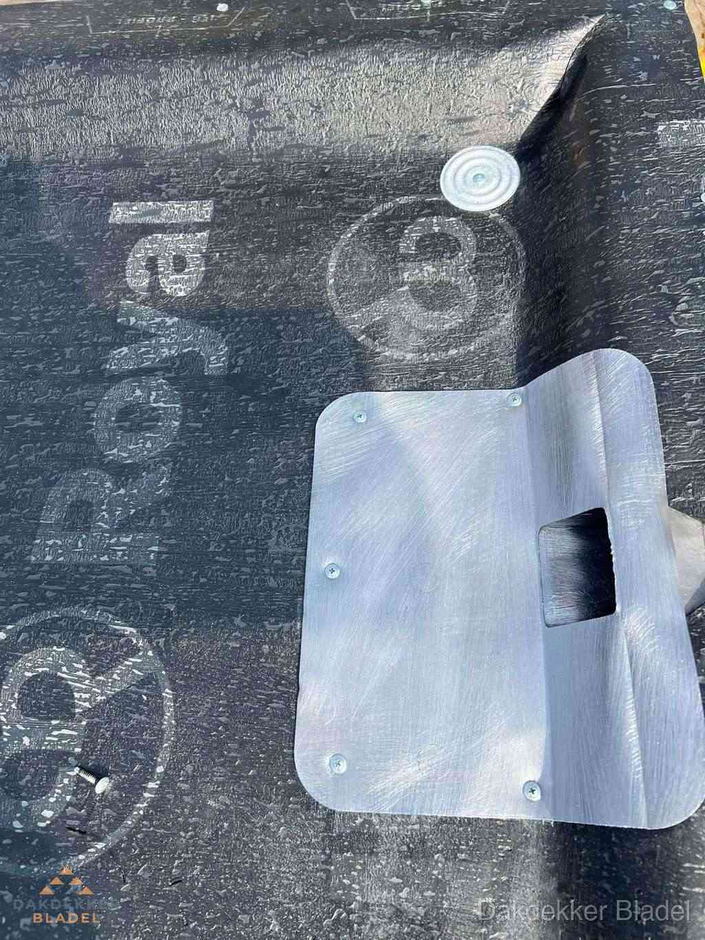 Dakdoorvoer met metalen afvoerplaat op bitumen dak in Bladel