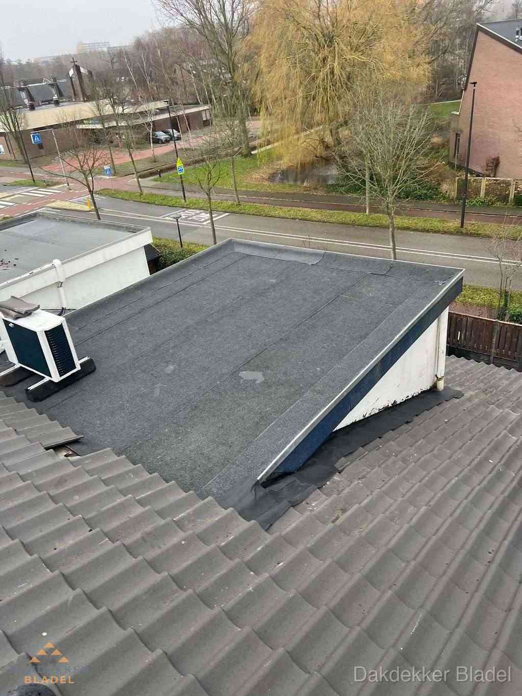 Plat dak met bitumen dakbedekking naast schuin pannendak in Bladel